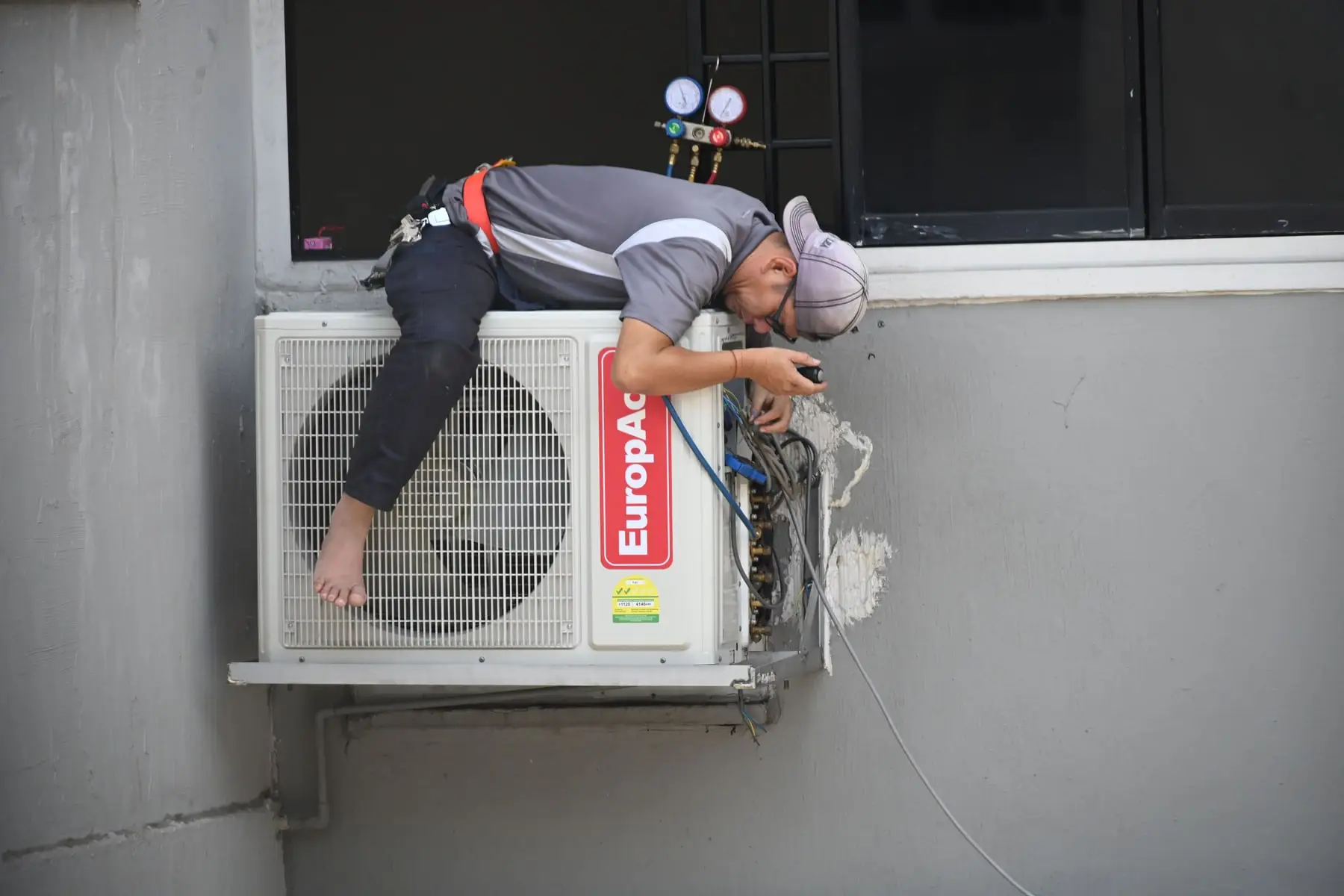 A technician working at an outdoor condenser unit