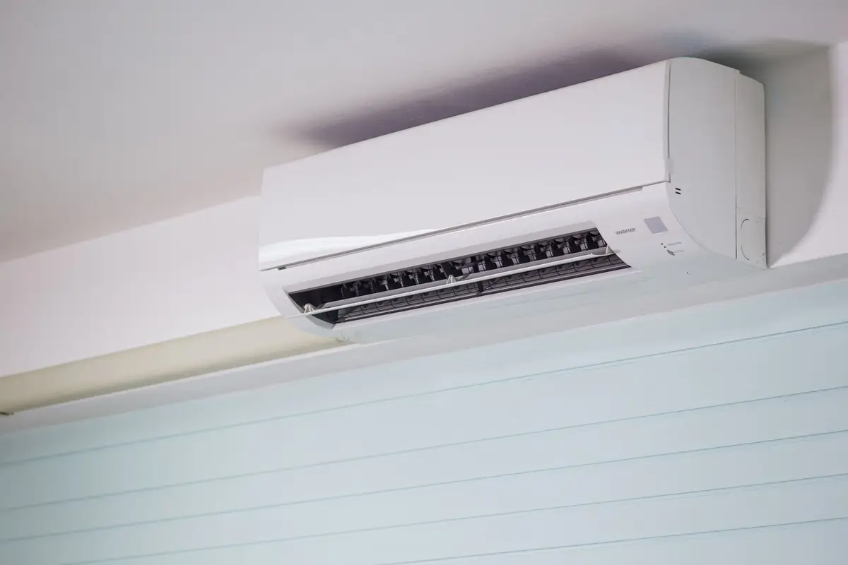 A wall mounted split system head above a window