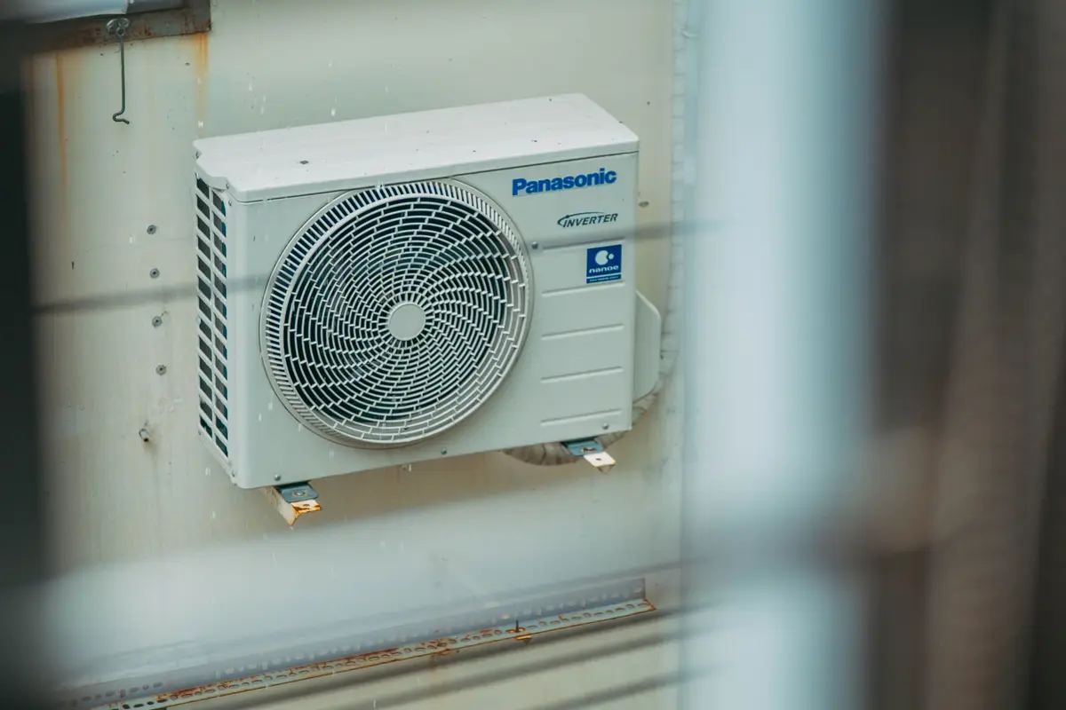 A condenser unit mounted on an exterior wall